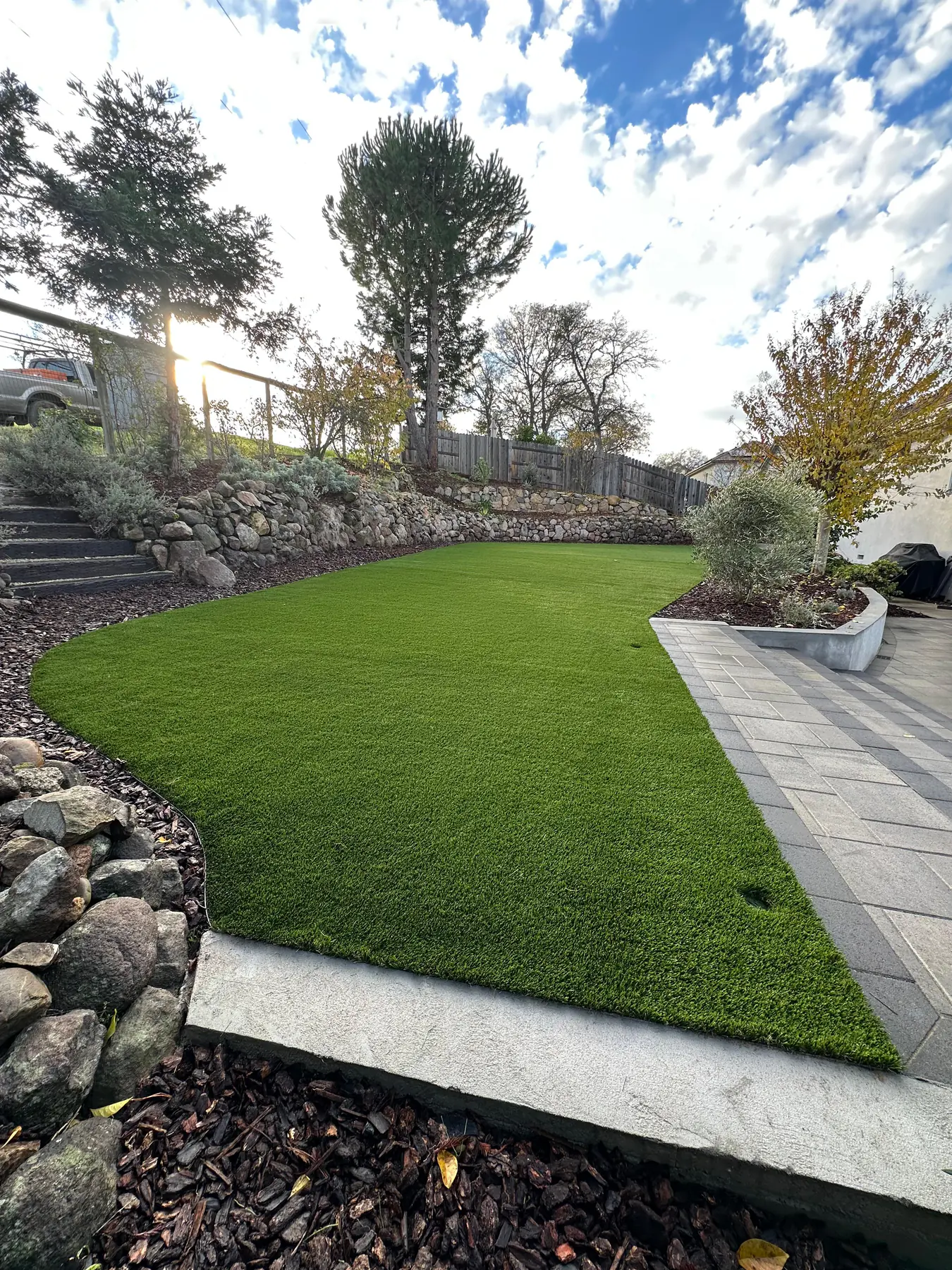 Artificial turf framed by boulders and planting