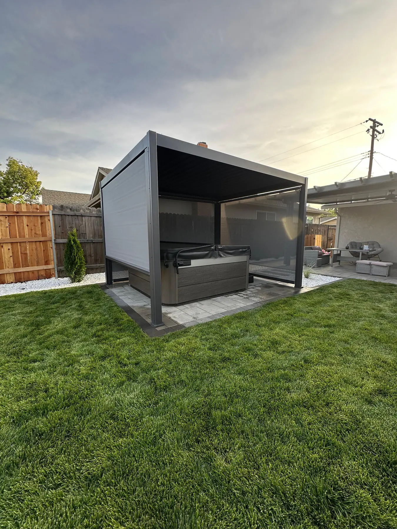 Custom outdoor kitchen with built-in BBQ grill, stone countertops, and stainless appliances in a beautifully landscaped backyard